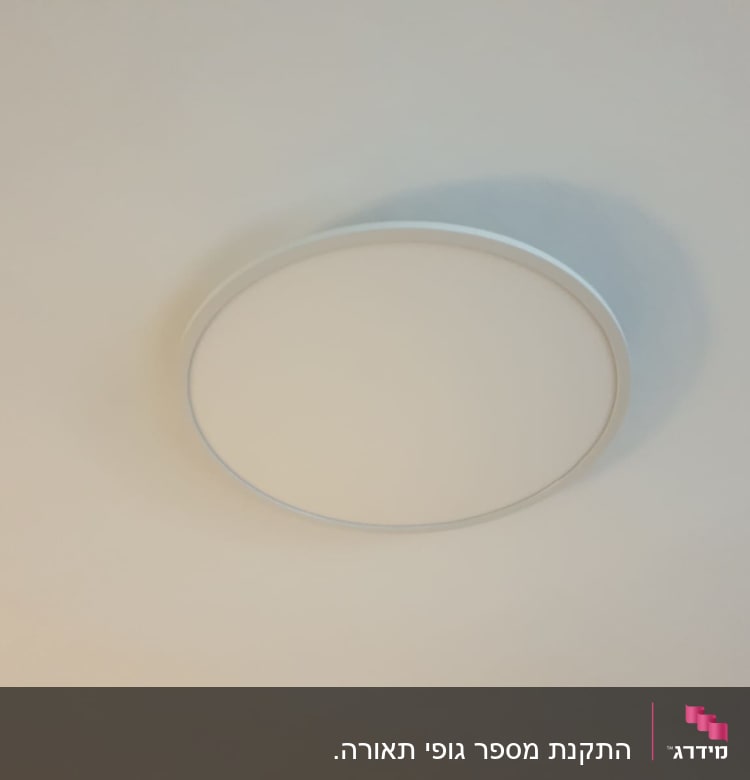מנורת תקרה עגולה מותקנת על תקרה לבנה
